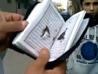 القرآن الكريم يحمي أحد المتظاهرين من القتل في ليبيا
